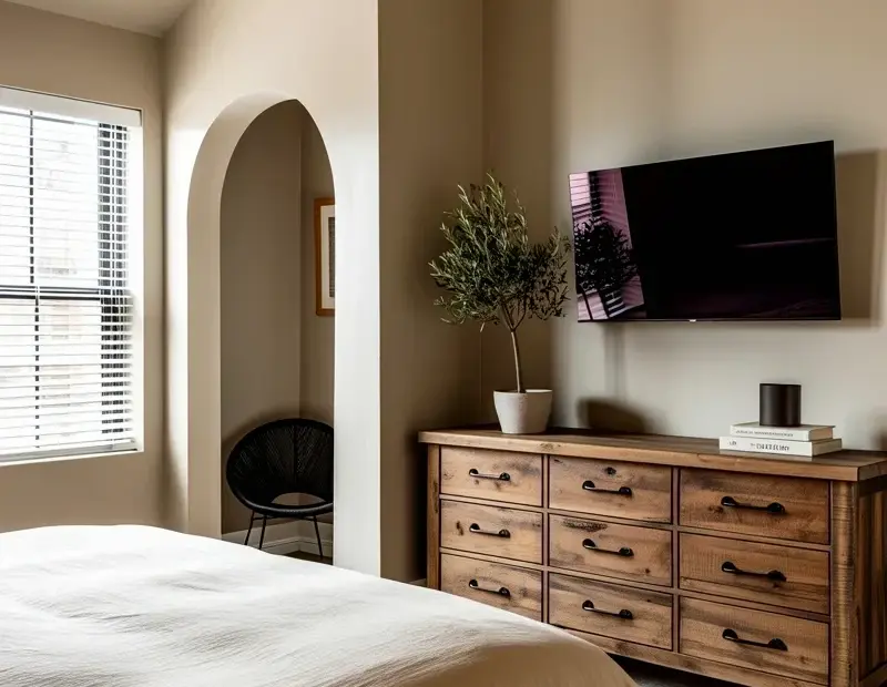 Neutral Bedroom Decor Ideas with an Arched Doorway and Rustic Dresser